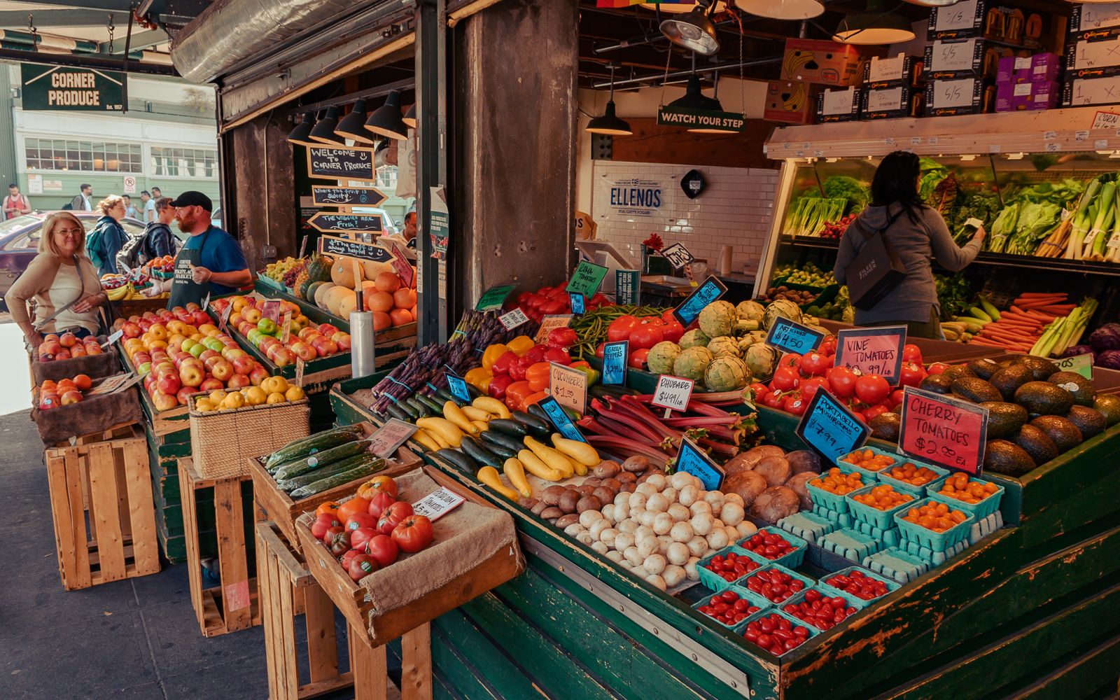 Shoppers browse crates of colorful fresh produce at a local farmers market.